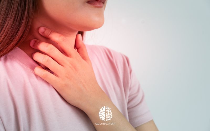 Hình ảnh một người đang ôm nhẹ vùng cổ với biểu hiện hoang mang, mệt mỏi | Người bệnh lo lắng nuốt vướng cổ họng do căng thẳng tâm lý